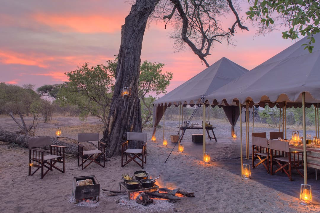 A luxurious safari camp glows beautifully under a stunning Botswana sunset.