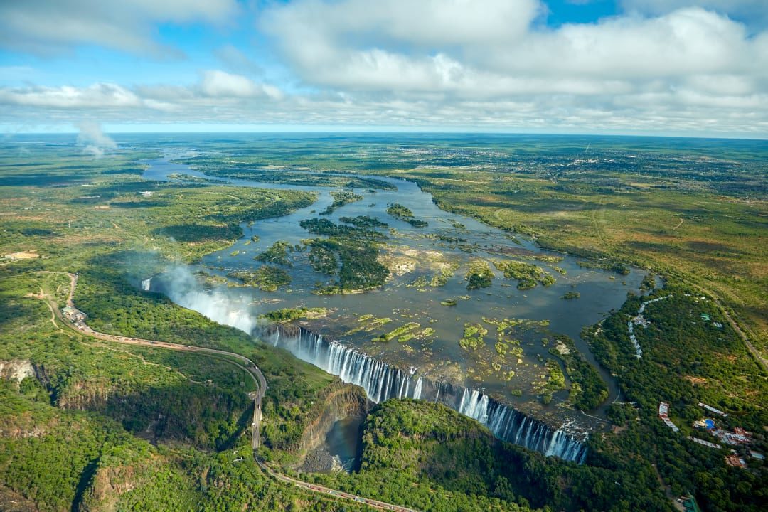 Water thunders down Victoria Falls, creating mist over Zambezi River.