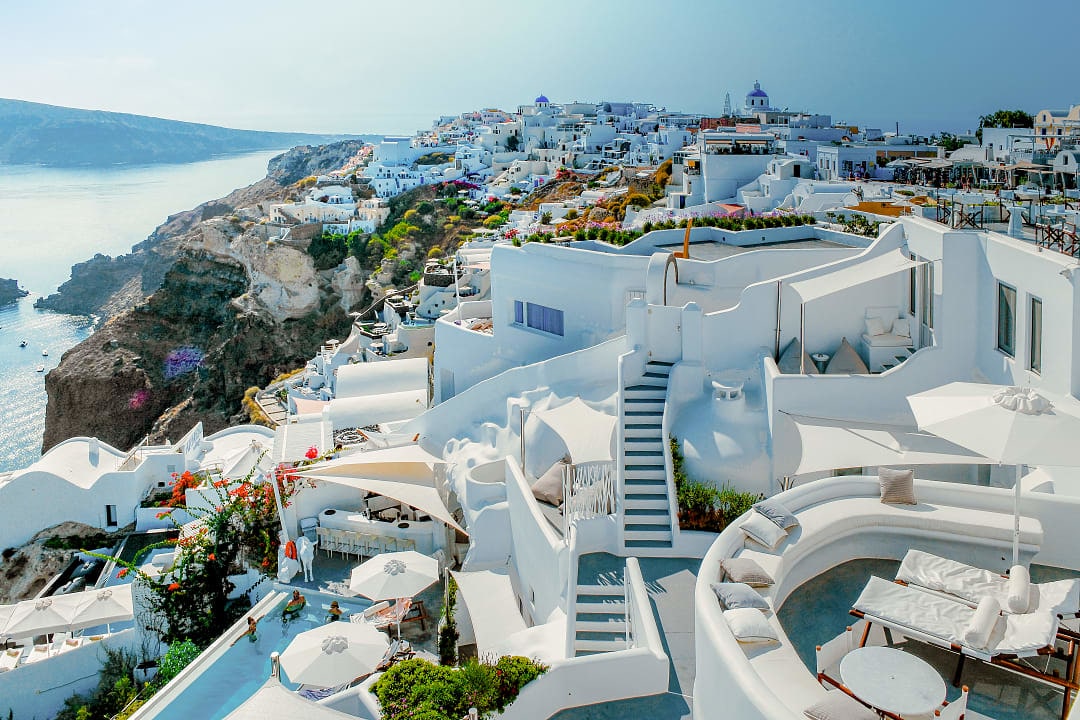 Oia’s whitewashed buildings overlook the Aegean Sea’s breathtaking blue waters.