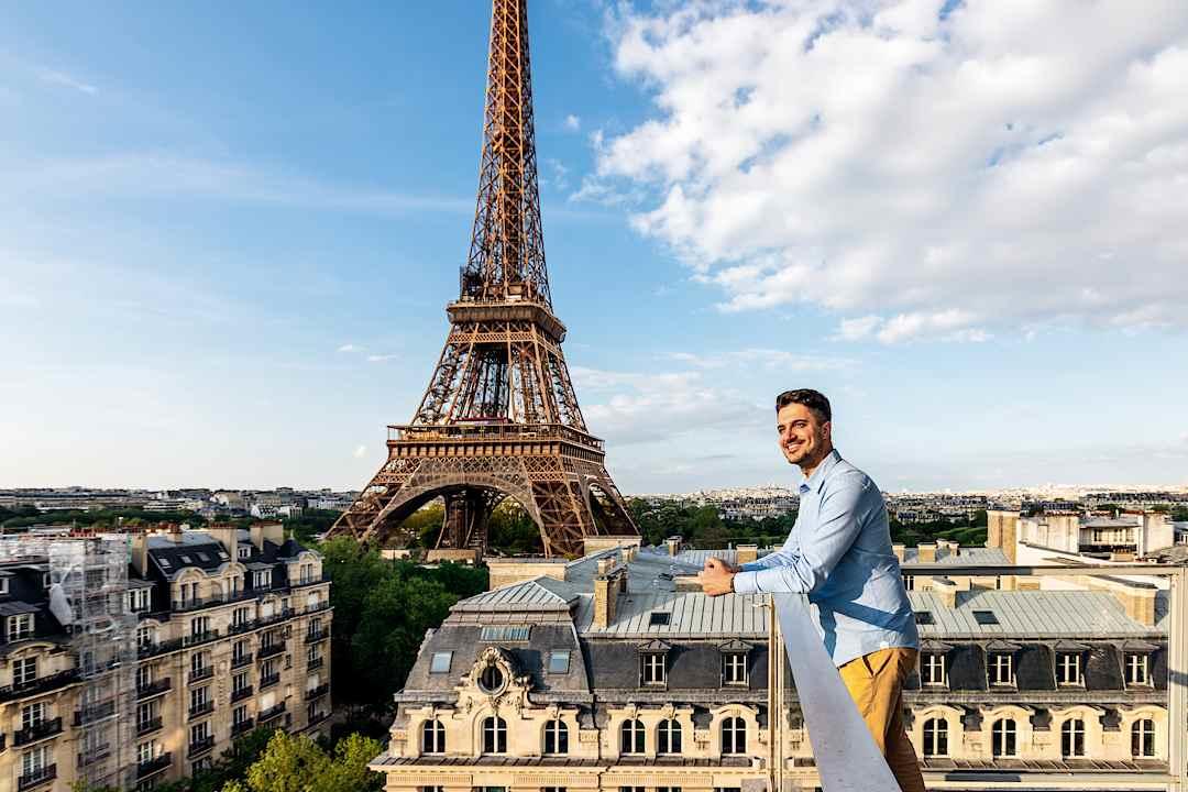 Man admiring the view from a rooftop in Paris.