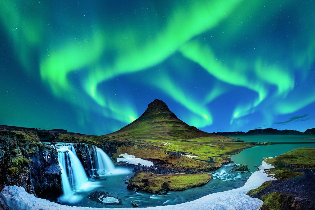 Northern lights over Kirkjufellsfoss and Mt Kirkjufell in Grundarfjörður, Iceland