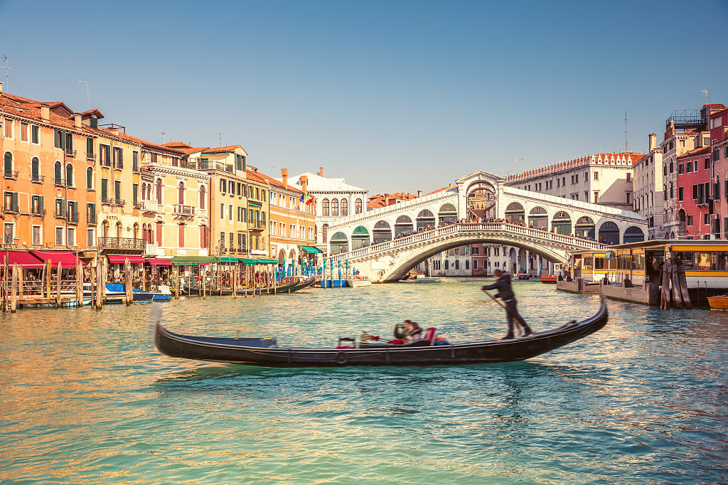 Couple riding in gondola near Rialto bridge in Venice, Italy