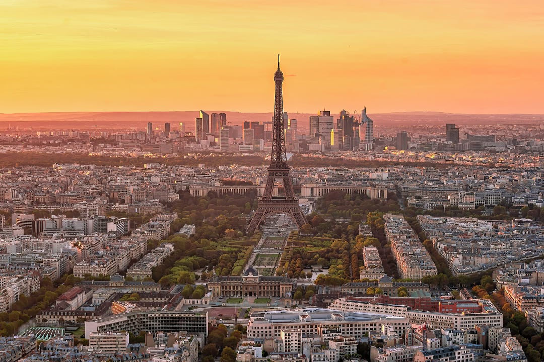 Sunset view of the Eiffel Tower in Paris, with the La Défense district in the background