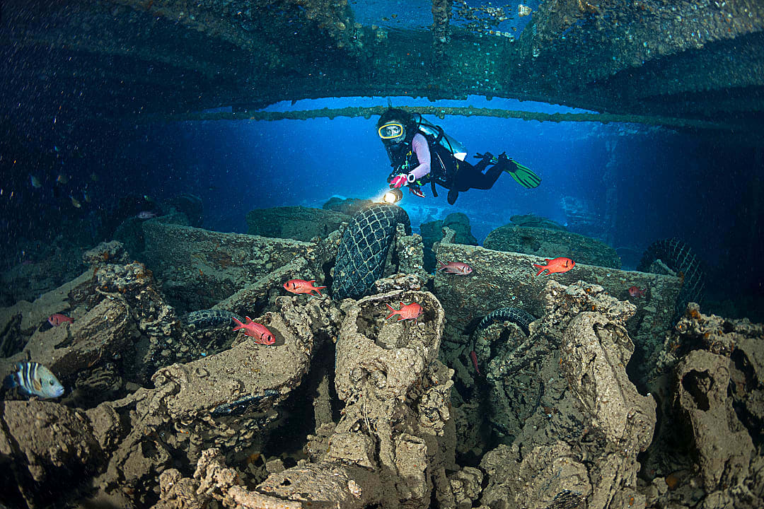 Scuba diver exploring wreckage with motorcycles in Ras Mohammed National Park, Egypt