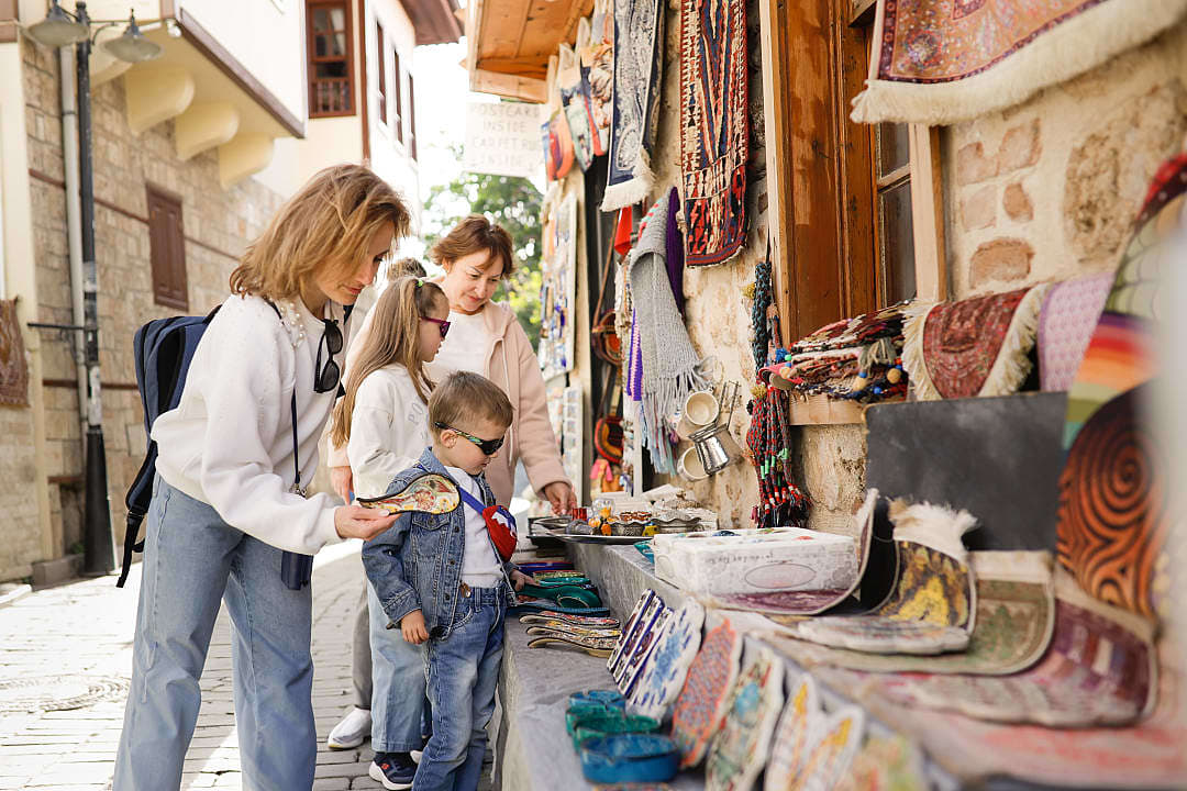 A family explores Istanbul’s bazaar, admiring handmade crafts and souvenirs.