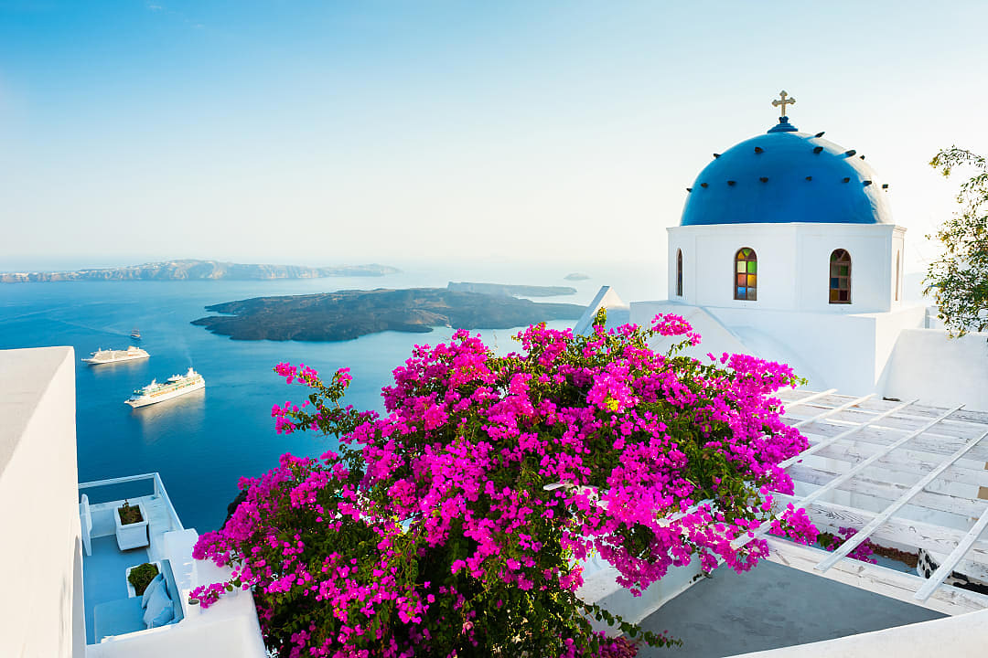 A blue-domed church overlooks the Aegean Sea in Santorini.