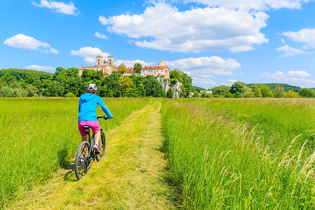 Woman biking through fields around the Tyniec Monastery in Kraków, Poland