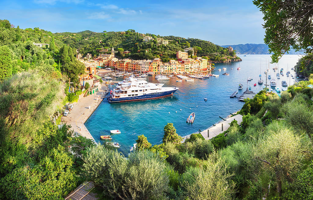 Yachts and small boats in the harbor of colorful coastal Italian town of Portofino