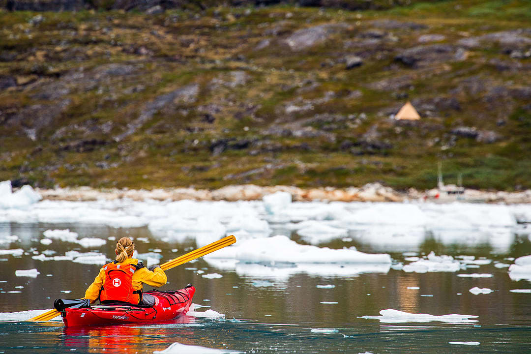Woman enjoying a kayaking experience in Greenland.
