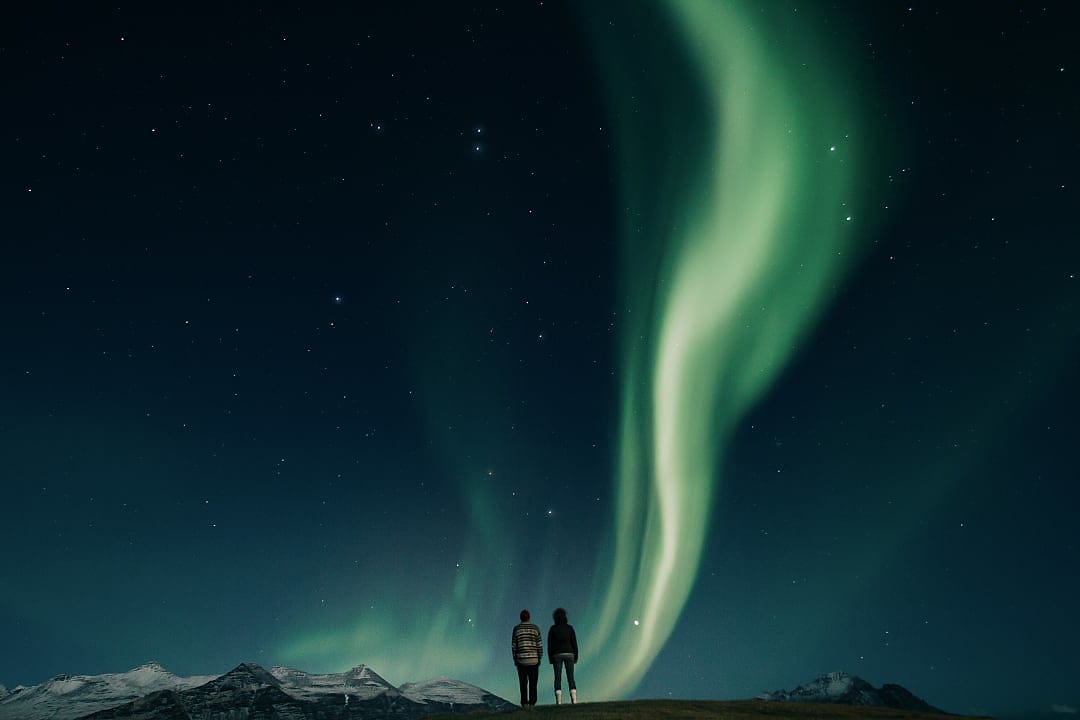 A couple admires the Northern Lights in Iceland