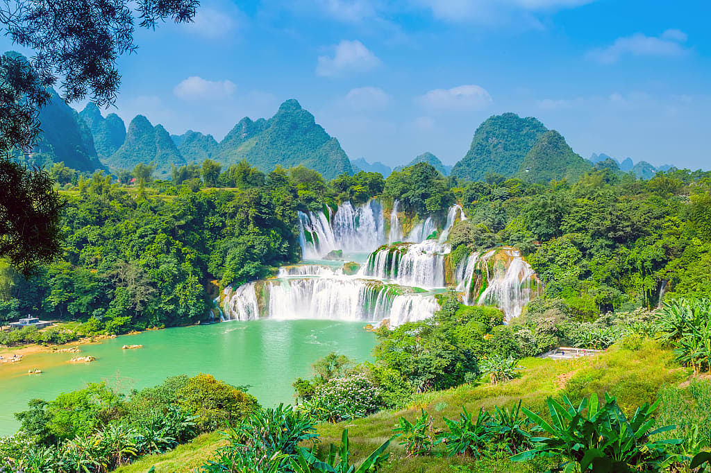 Lush green landscape surrounding Ban Gioc waterfall and Quây Sơn River in Vietnam