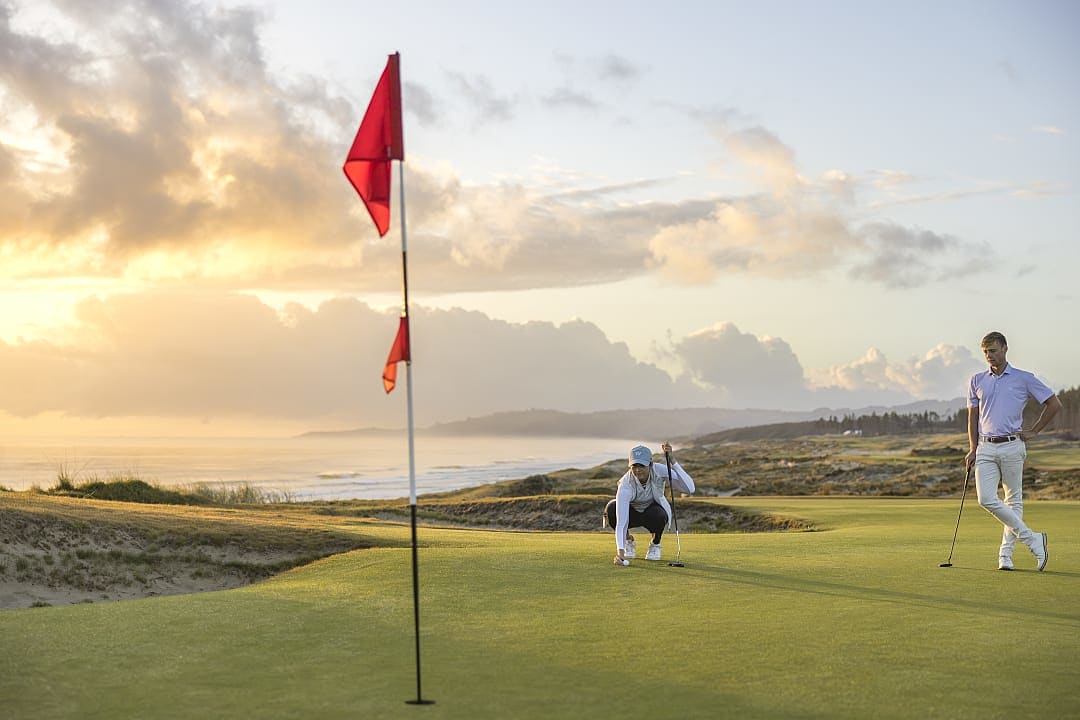 Couple golfing at Te Arai Links in Auckland, New Zealand