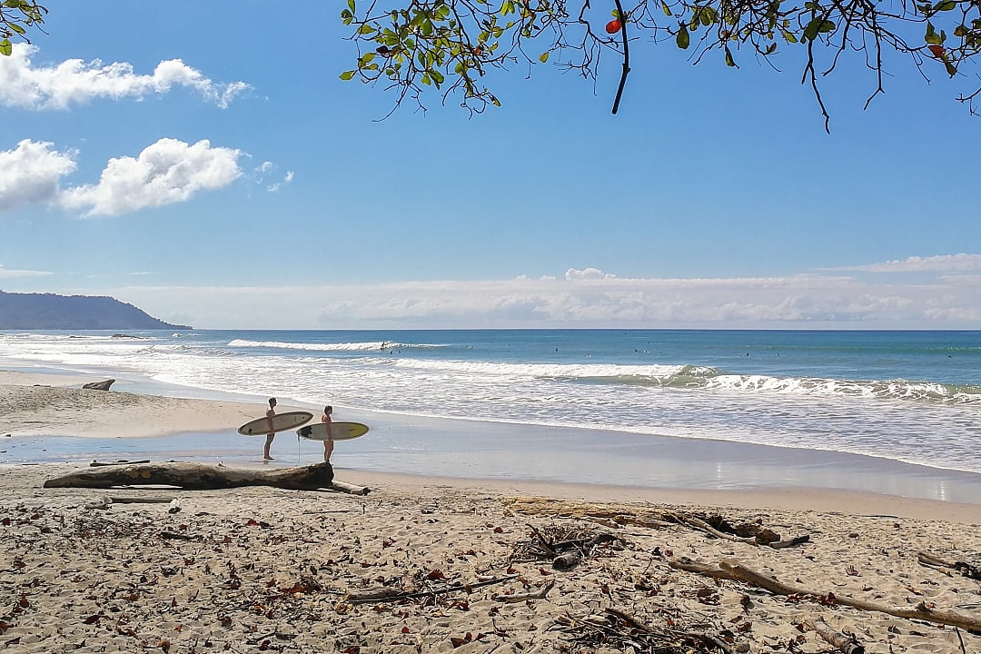 Two surfers standing on Santa Teresa beach, Costa Rica