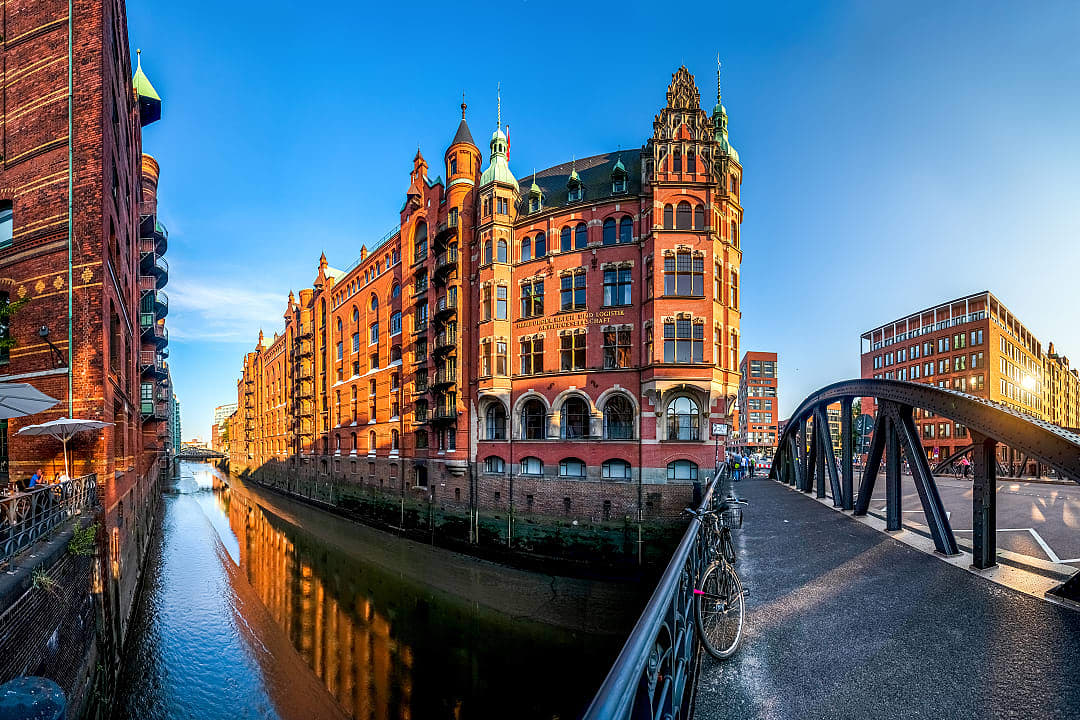 Historic red-brick warehouses and a bridge in Hamburg’s Speicherstadt district at sunset, Germany