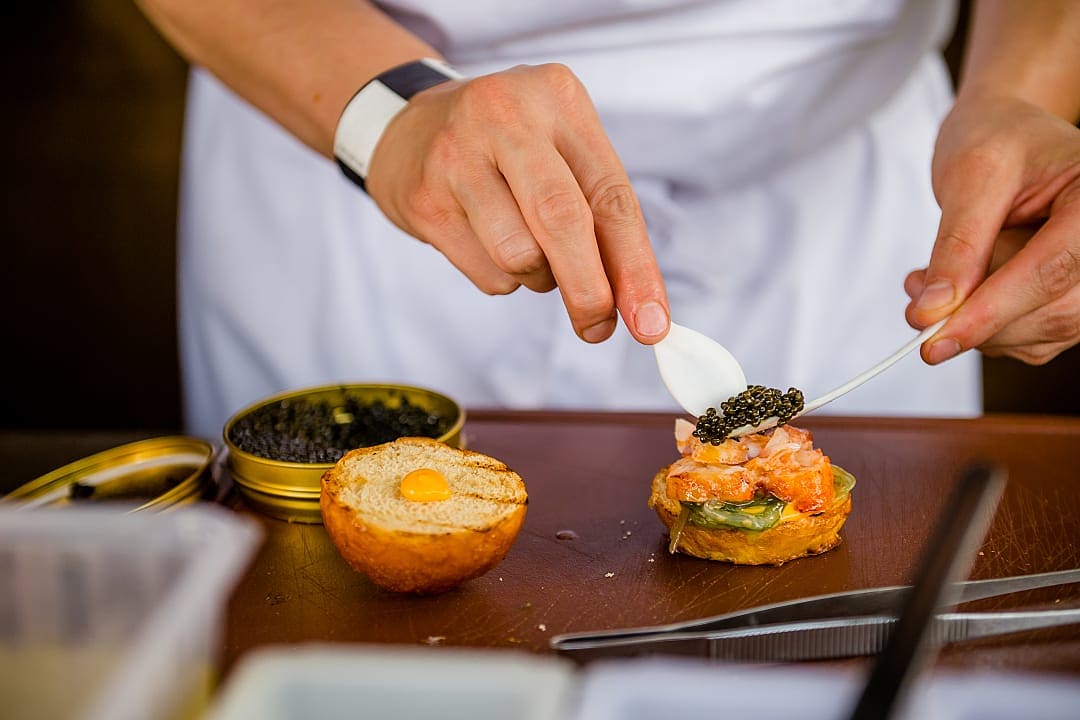 Chef preparing gourmet dish with caviar and brioche at the Gourmet Festival Budapest, close-up view