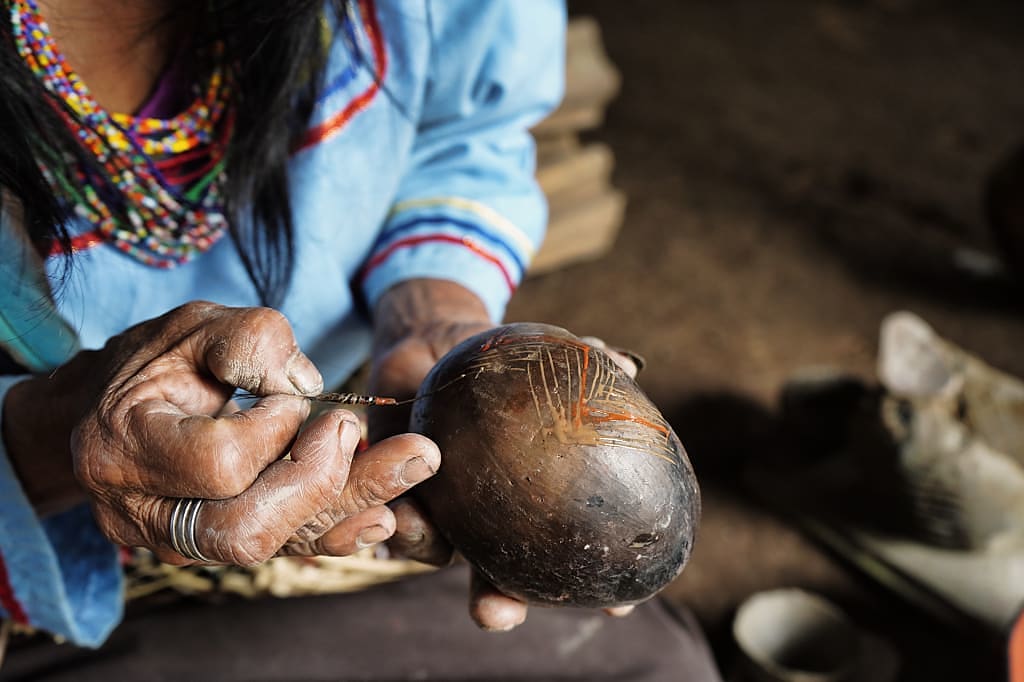 Indigenous Amazonian woman painting mokawas in Ecuador