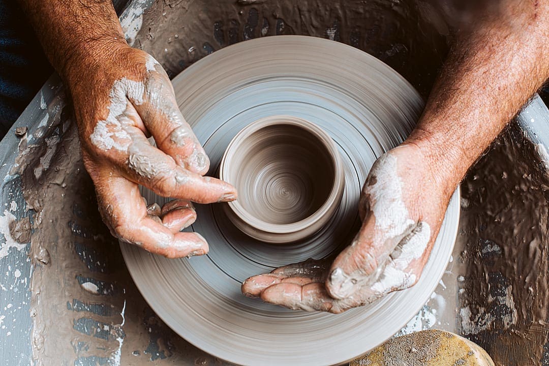 Potter working on clay on a wheel, Ireland.