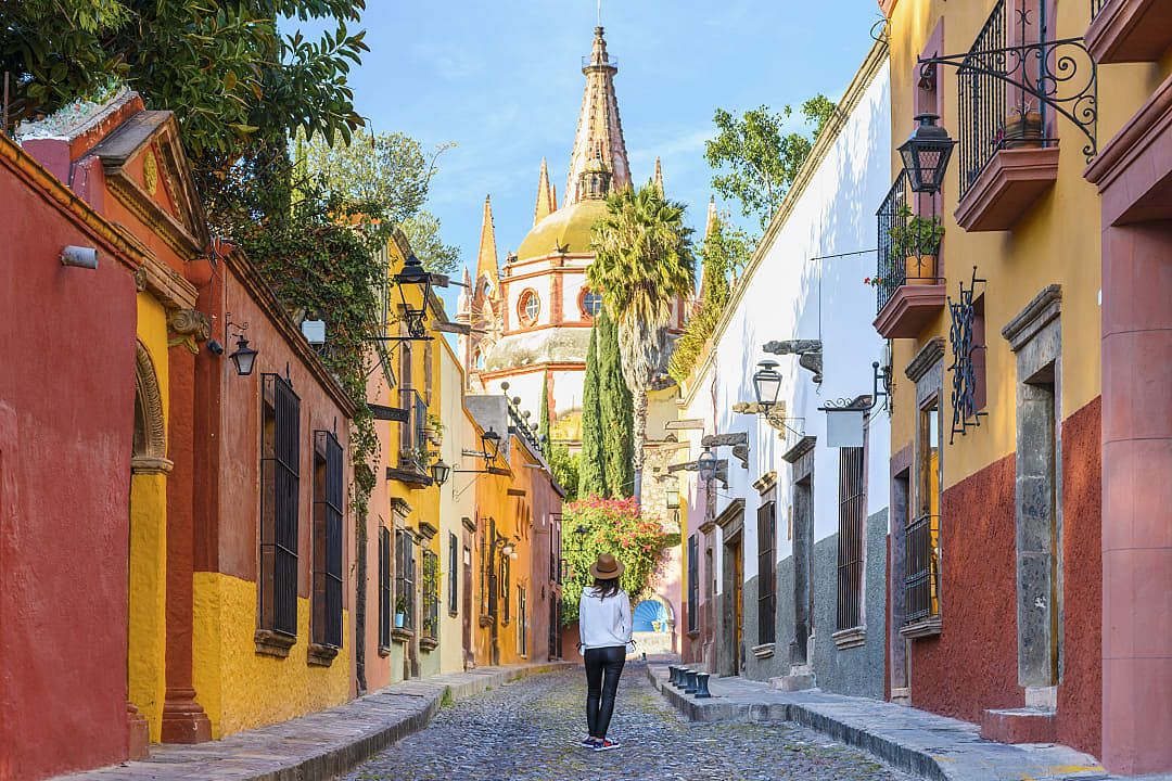 Woman walking on the cobblestone street in colorful San Miguel de Allende, Mexico