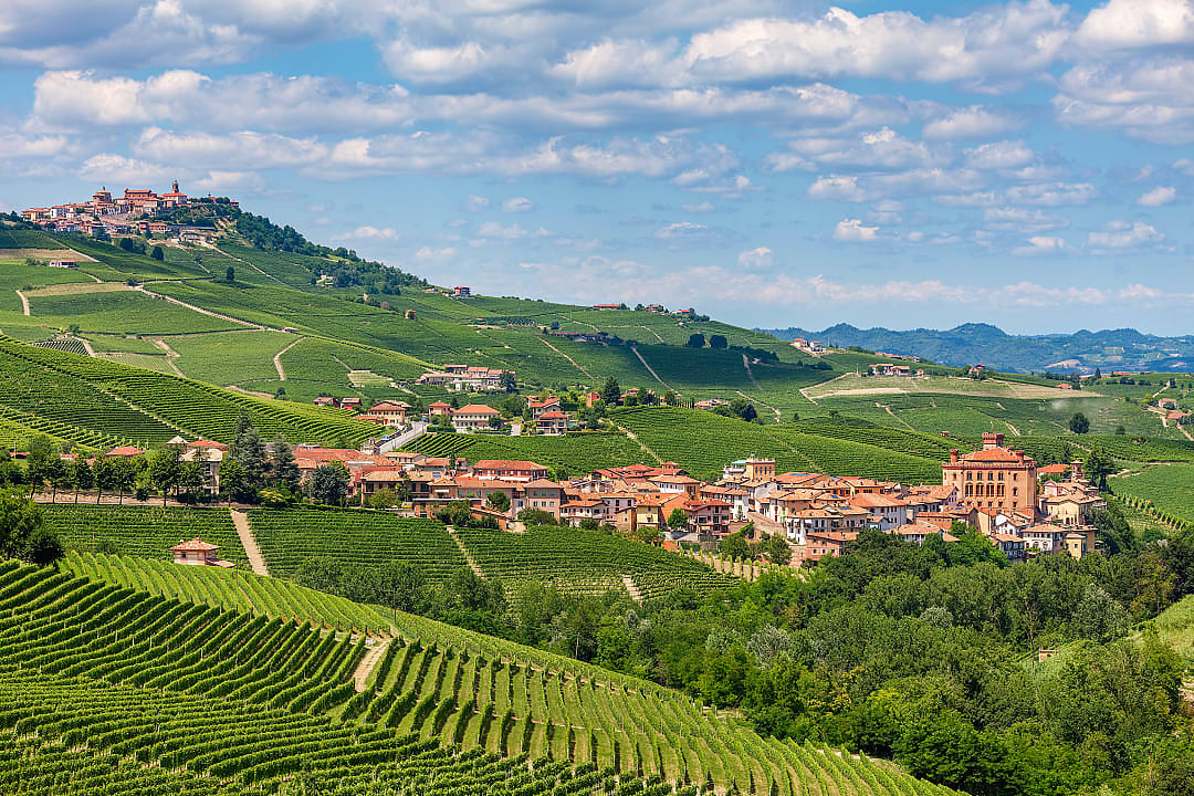 Village of Barolo surrounded by vineyards with La Morra on the hill in the distance in Langhe, Italy