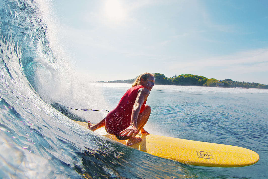 Woman surfing in the Maldives