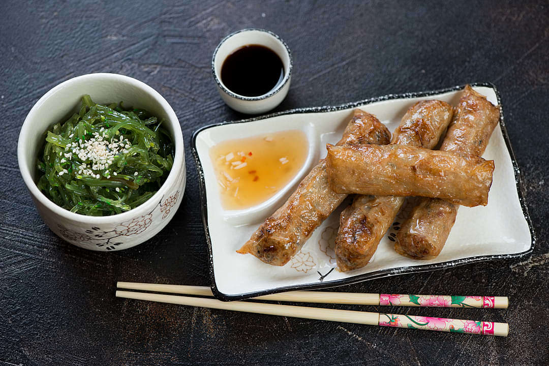 Vietnamese fried springs rolls, Nem Ran, with dipping sauce and seaweed salad