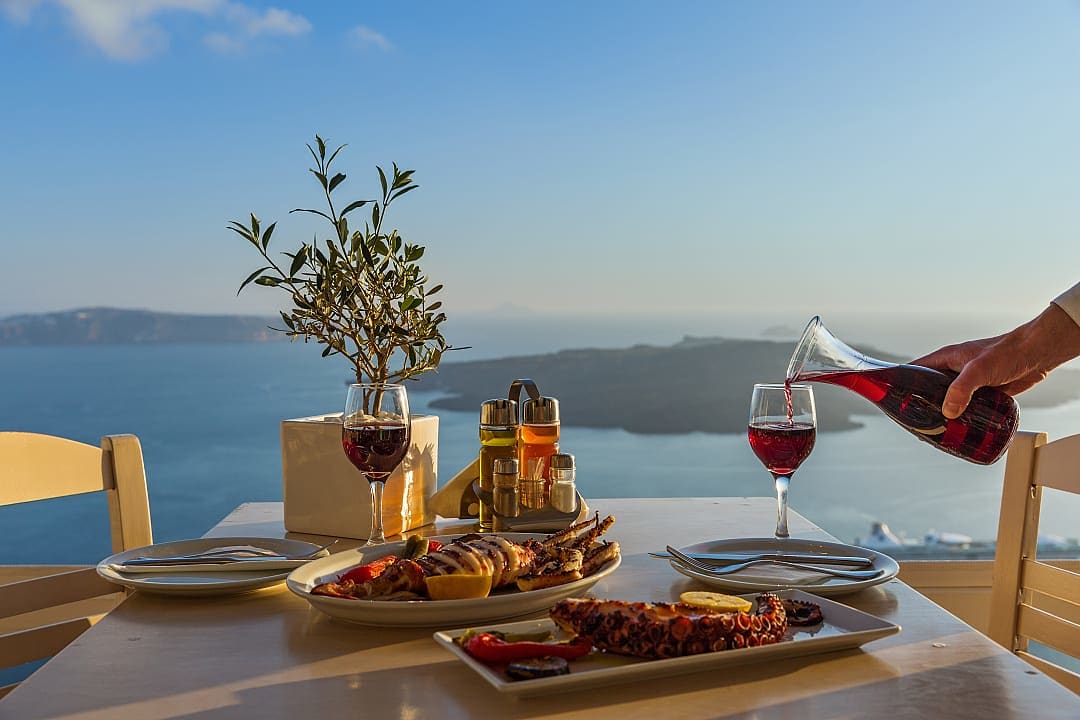 Seafood dinner and wine at a table with a view in Santorini, Greece