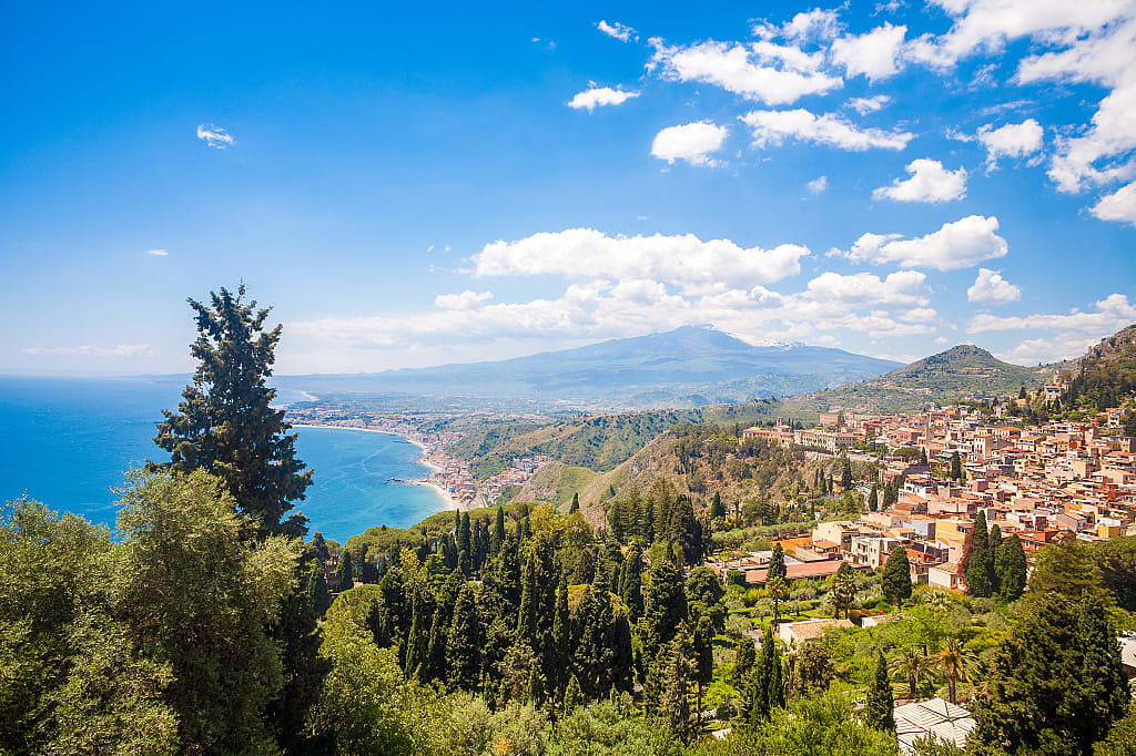 Taormina's Giardini-Naxos bay with Mt Etna and Catania in Sicily, Italy  