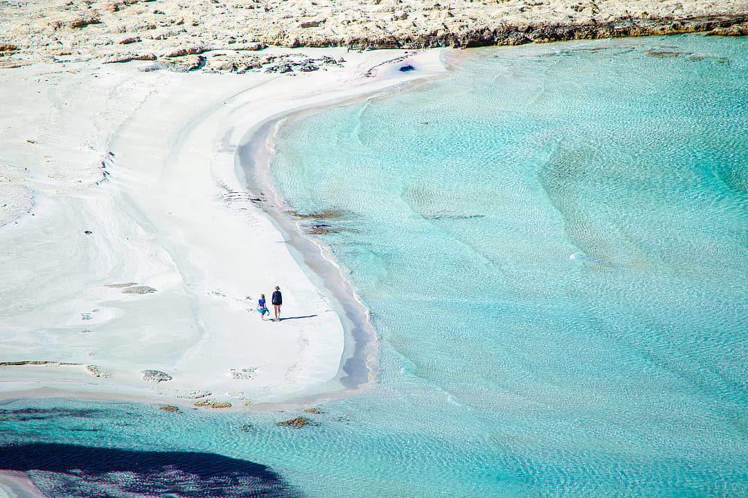 Mother and daughter walking at Balos Beach in Crete, Greece