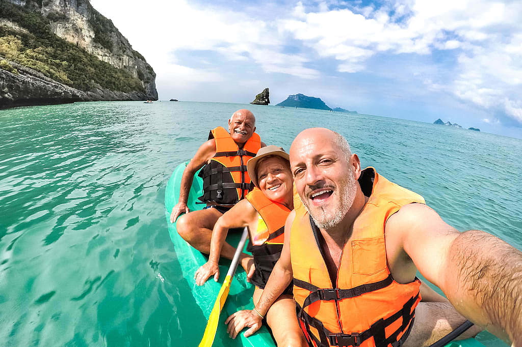 Senior travelers taking a selfie while kayaking in Thailand