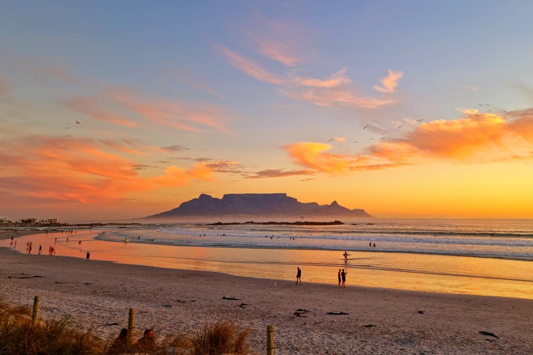 The sun sets over Table Mountain, setting the Atlantic ablaze with fiery hues.