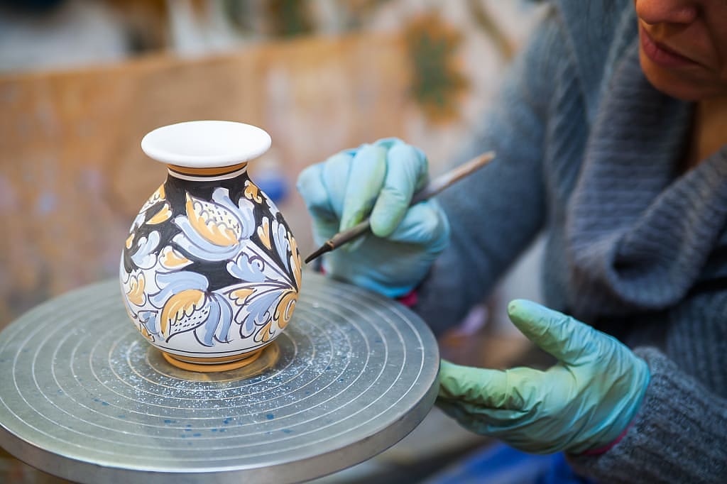 Ceramic vase being decorated b a local artisan in Caltagirone, Italy