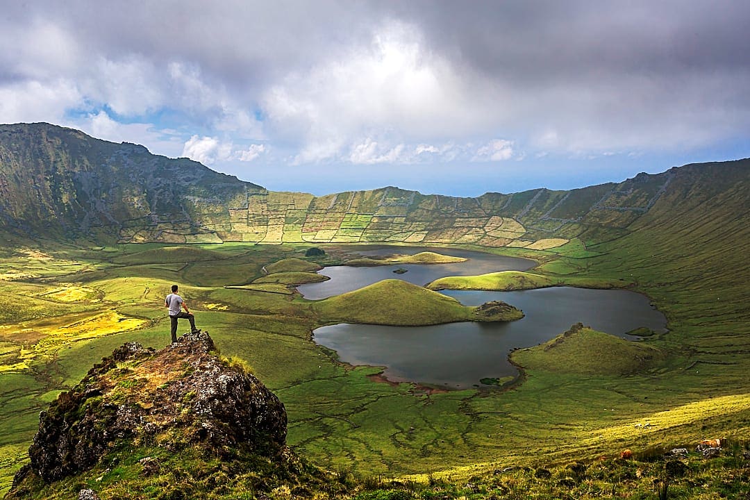 Man admiring the stunning volcanic crater and lakes of Caldeirão, Corvo Island, Azores, Portugal
