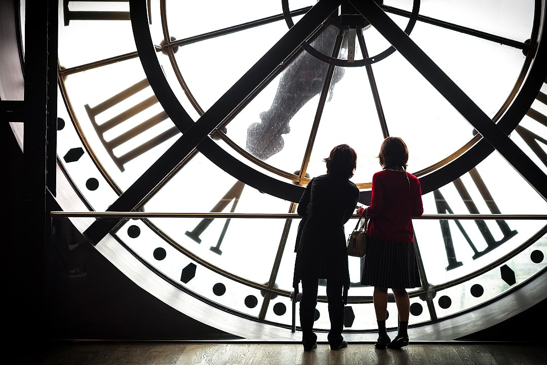 Kids behind the clock at d'Orsay Museum in Paris, France