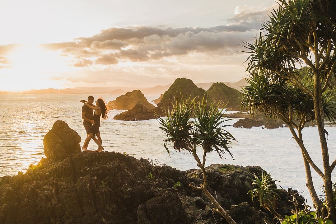 Honeymoon couple at sunset on the rock in Bali, Indonesia