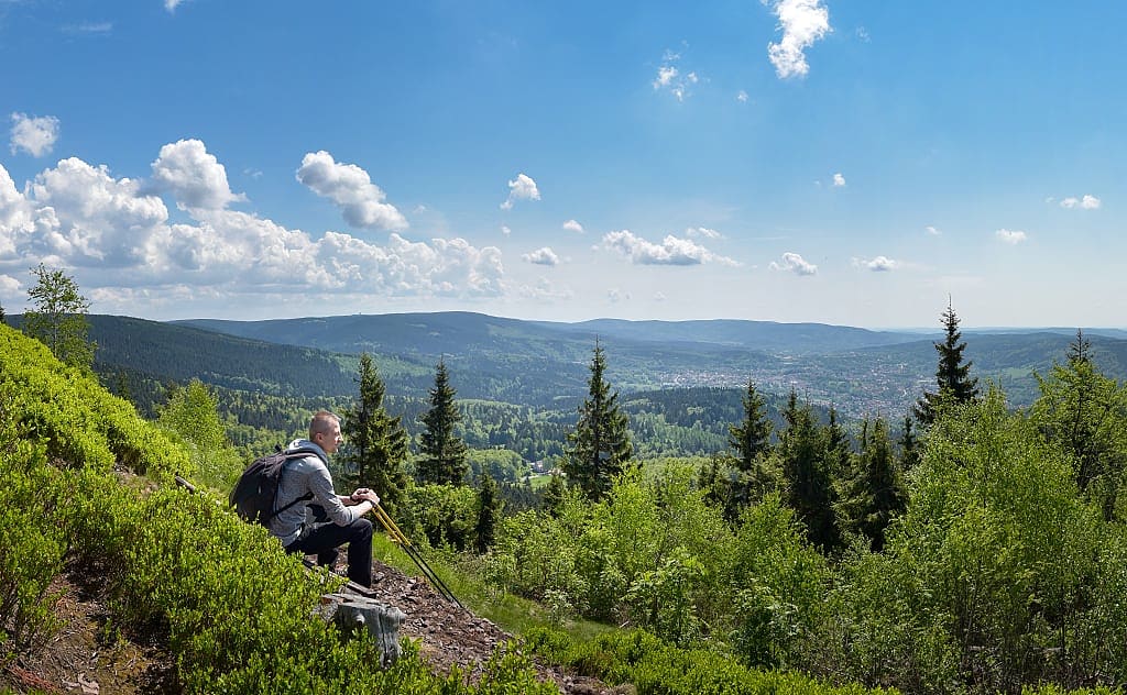Hiker taking in the scenic landscape of mountains and trees on the Rennsteig Trail in Thuringian Forest