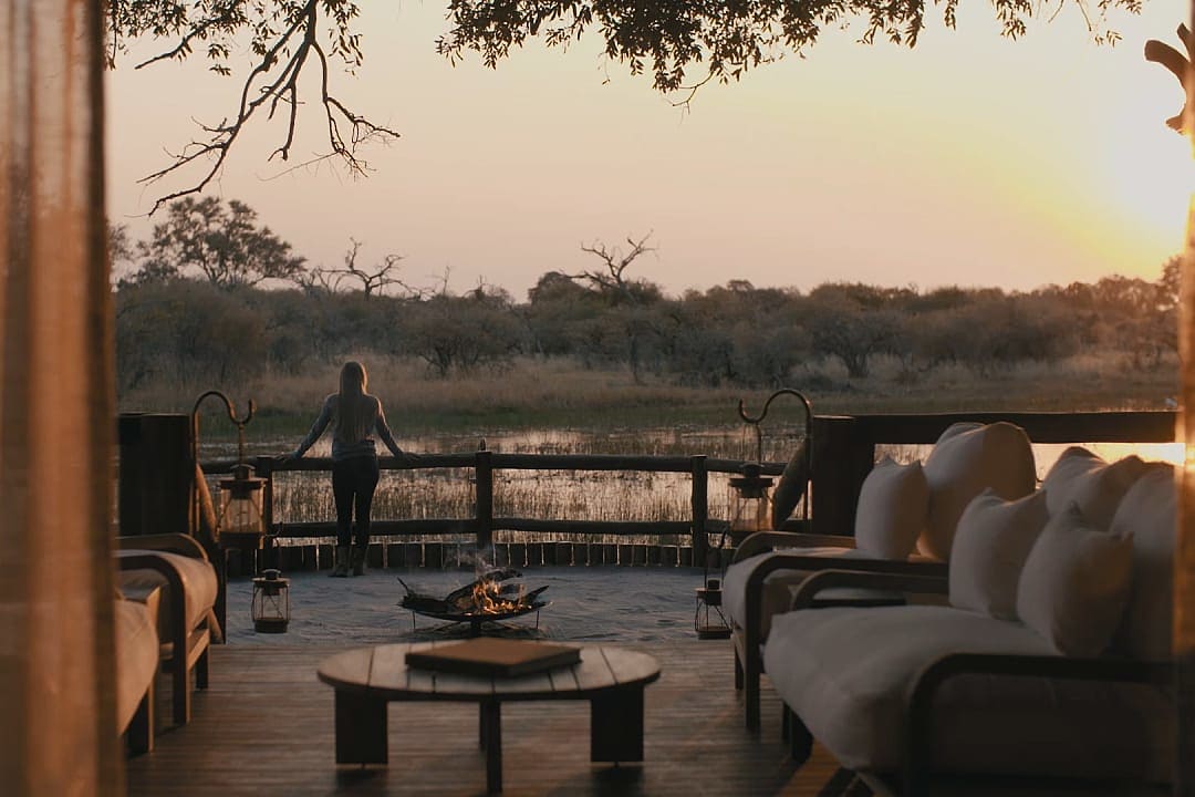 Woman on a terrace overlooking the water in the Okavango Delta in Botswana