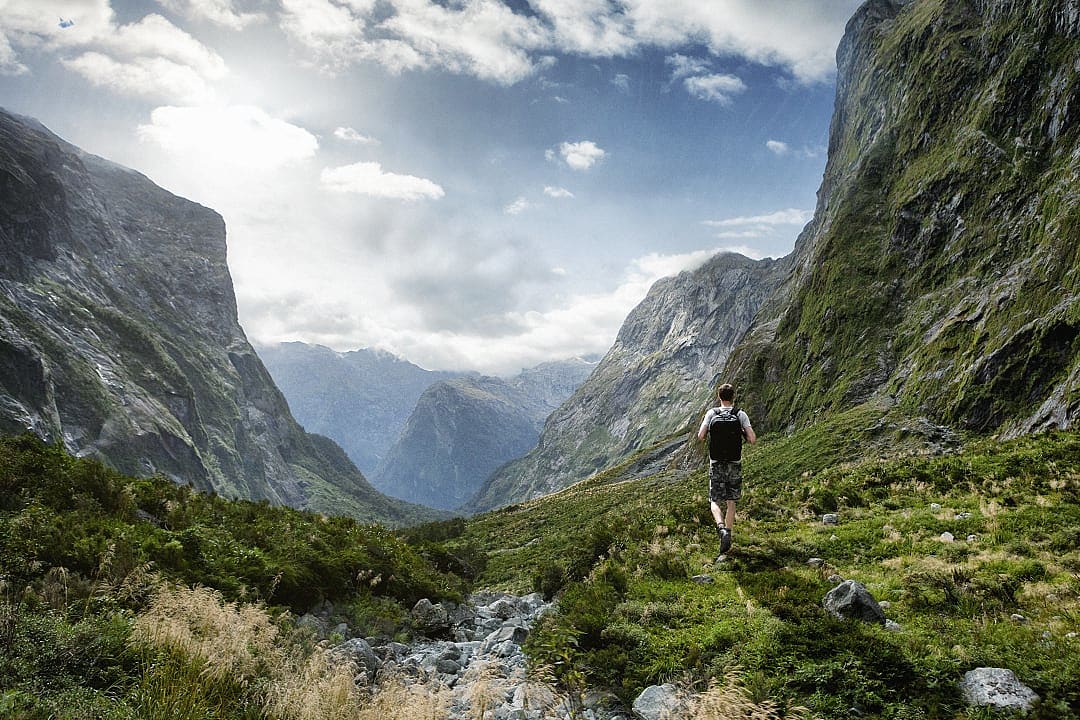 Man hiking amongst the beautiful landscape of the Fiordland National Park