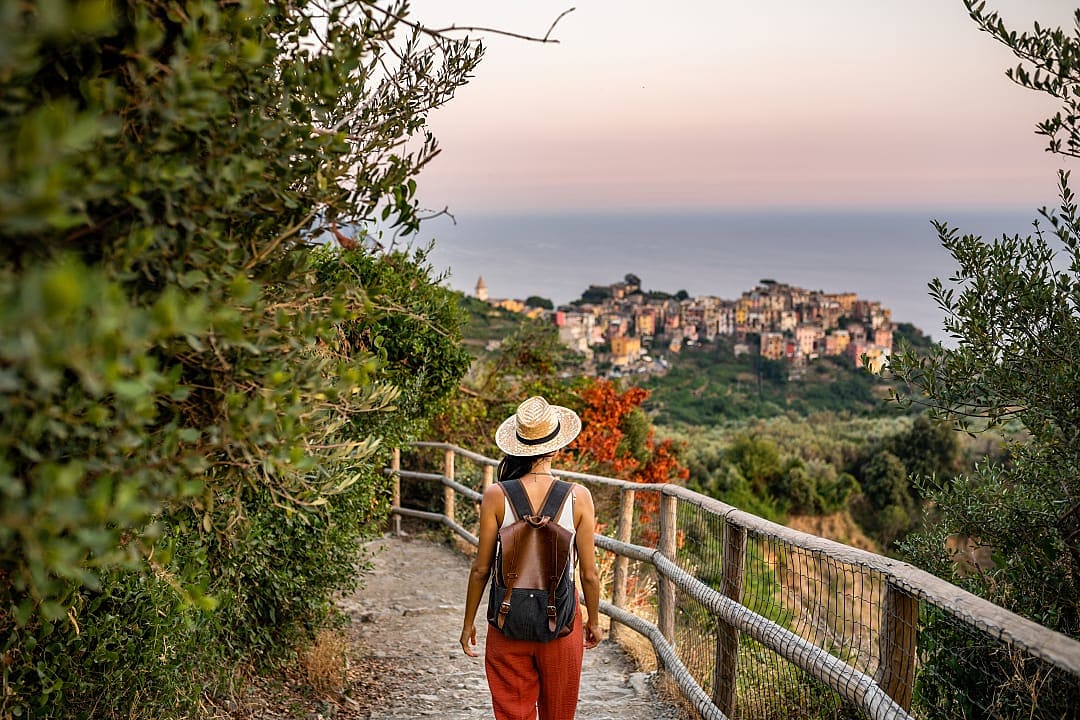 Female traveler walking the trail towards Corniglia in the Cinque Terre, Italy