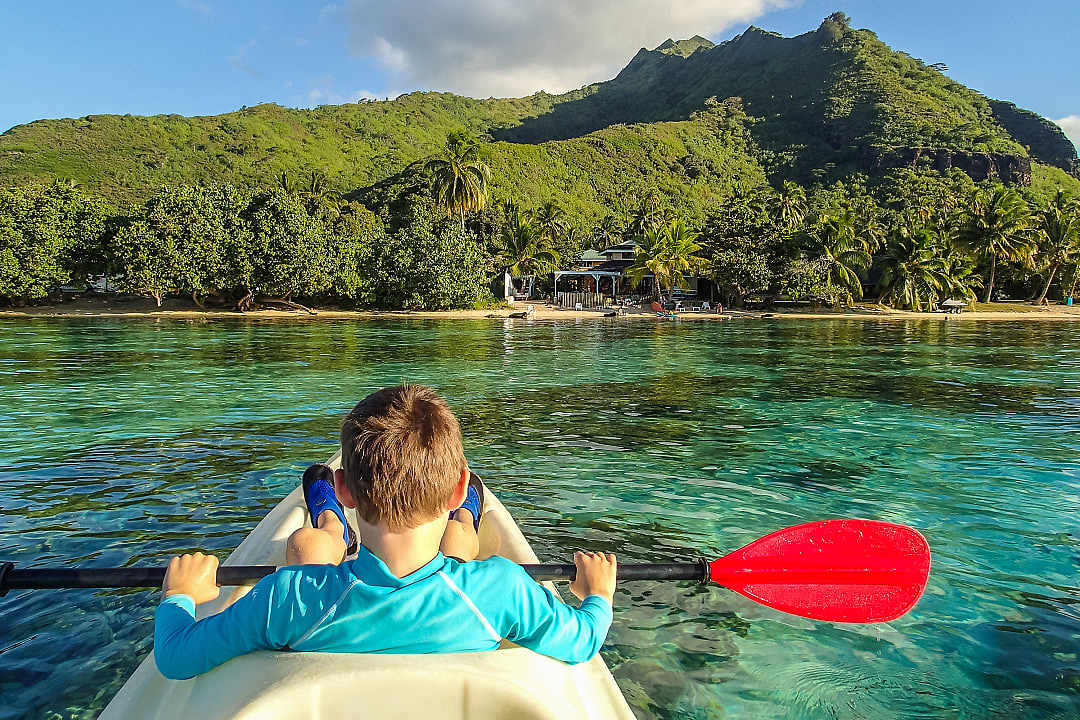 Child kayaking in the Moorea Lagoon, French Polynesia. 