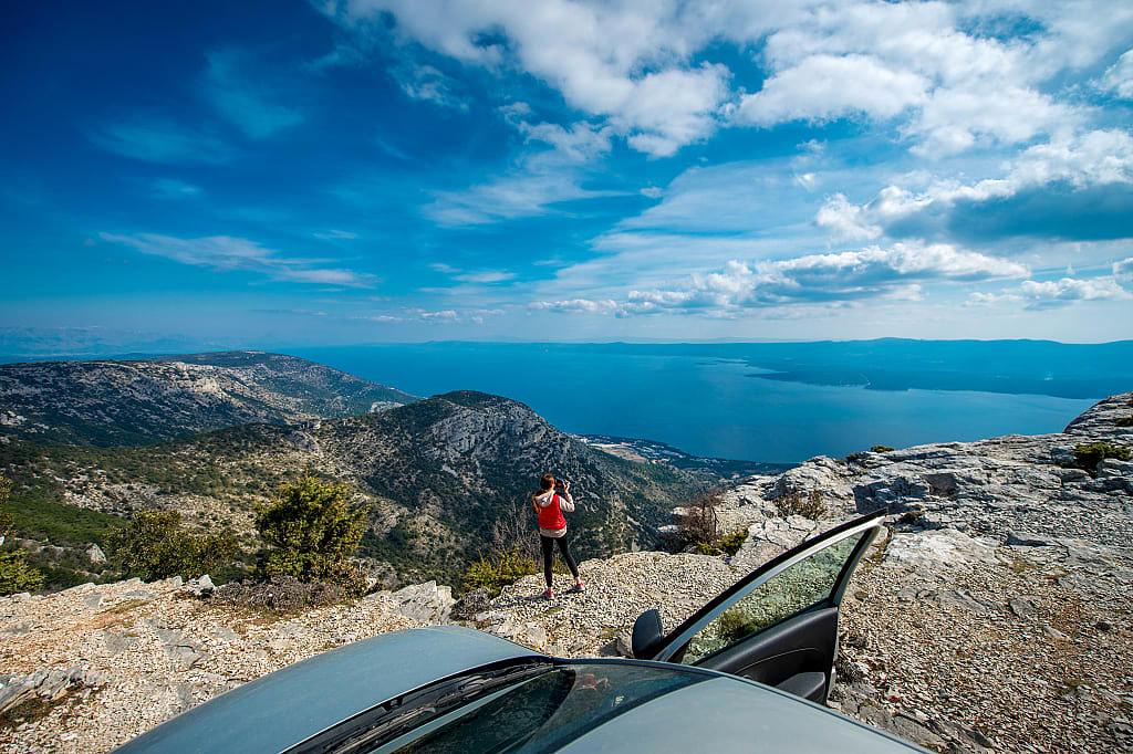 Tourist taking a photo of the view from the roadside in Croatia