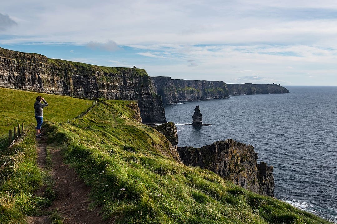 Hiker enjoying the iconic scenery of the sea cliffs of Ireland.