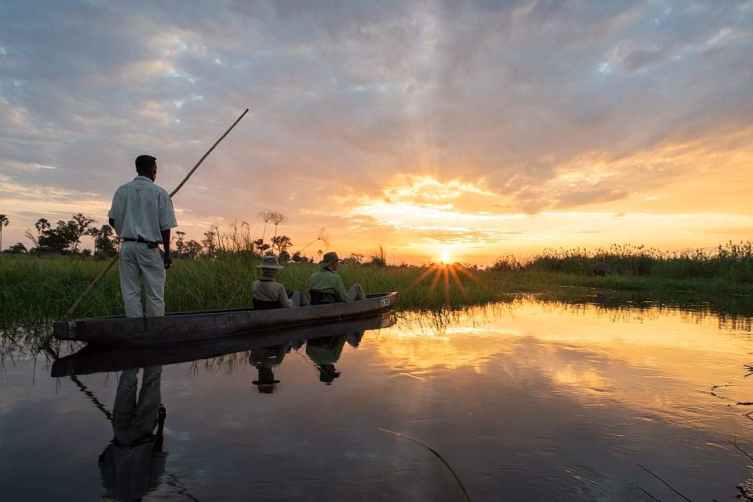 Couple on a guided sunset mokoro boat ride in Botswana