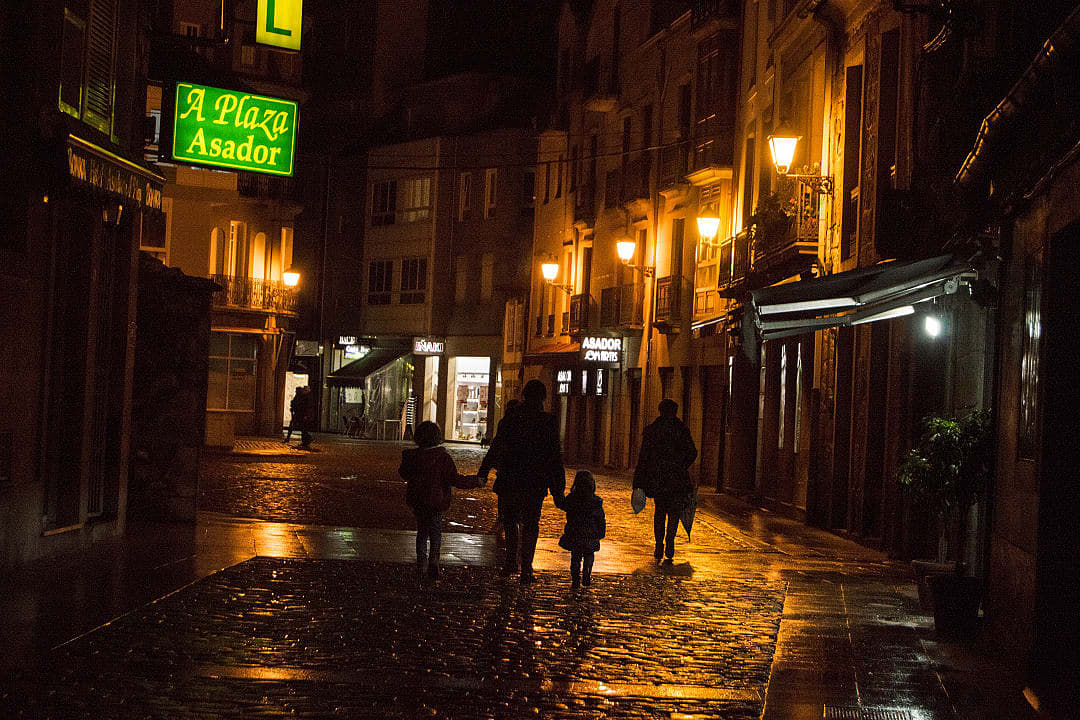 Family walking together at night, Spain.