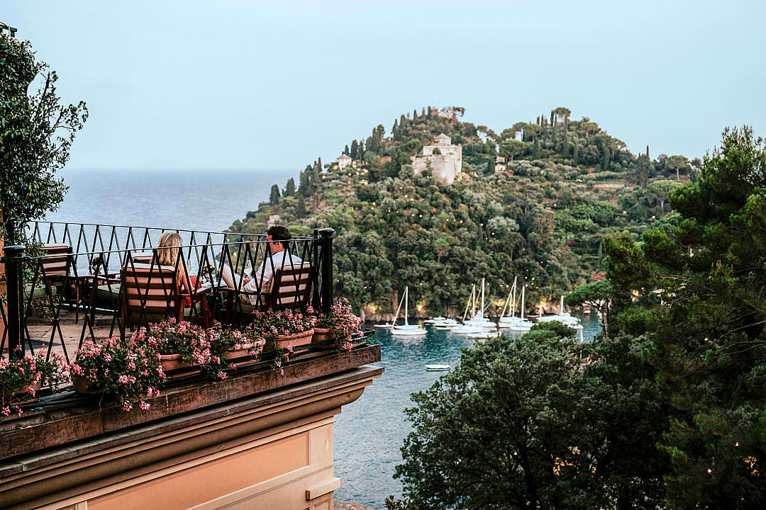 Couple enjoying scenic terrace view overlooking Portofino harbor.