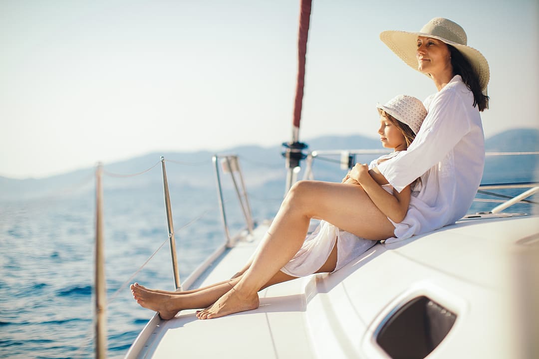 Mother and child relaxing on a yacht sailing in the Mediterranean Sea