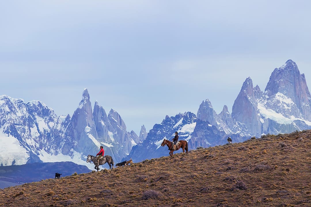 Gauchos riding against the backdrop of Mount Fitz Roy in Argentine Patagonia
