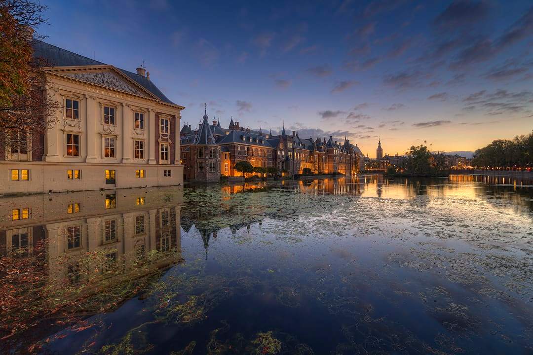 The Mauritshuis museum reflected in the Hofvijver lake at sunset in The Hague.