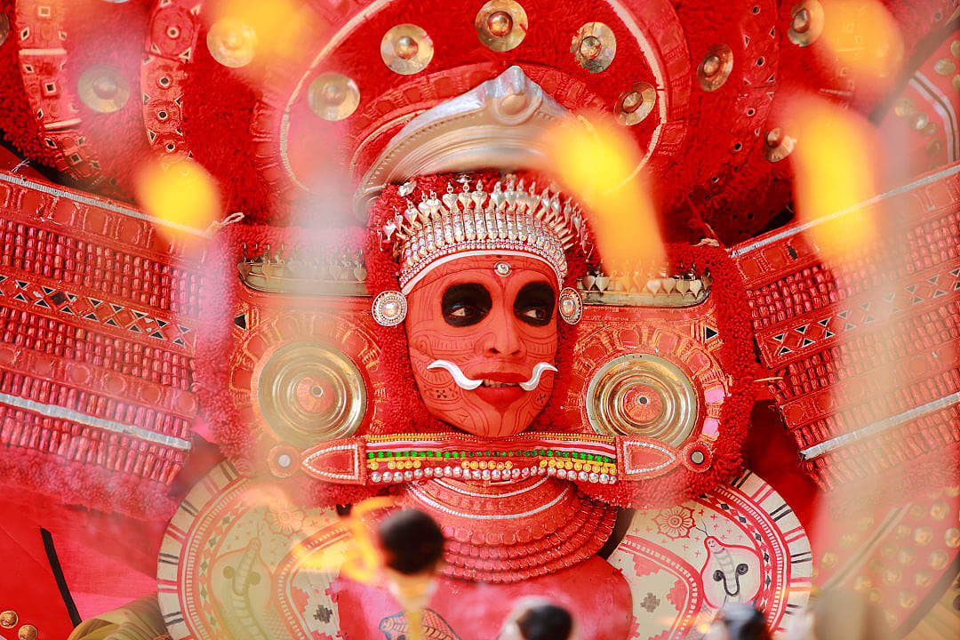 Dancer at a traditional Theyyam ceremony in a temple in Kerala.