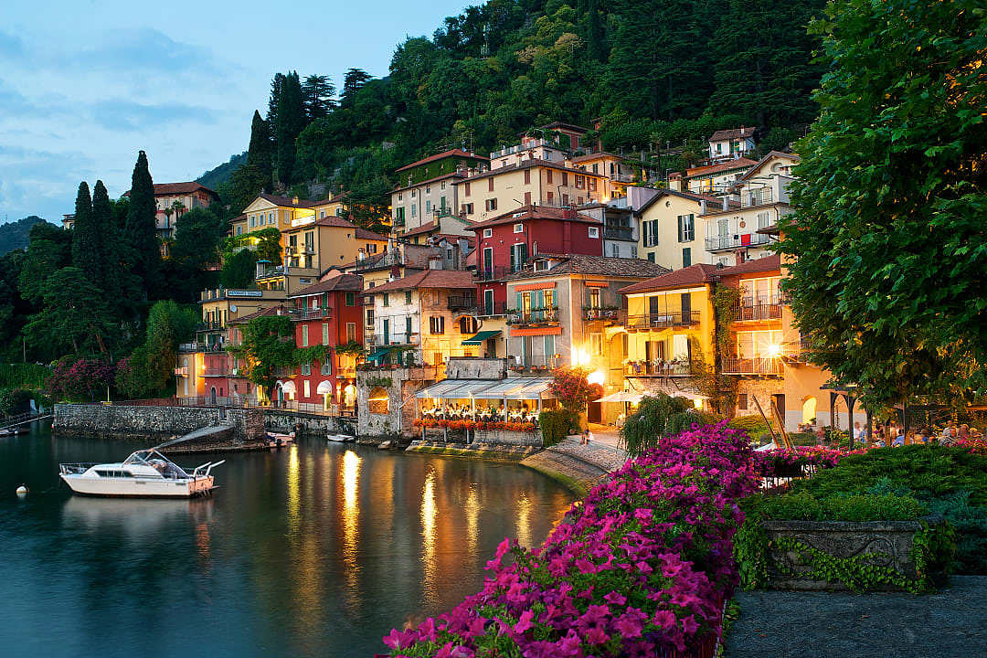 Colorful hillside villas overlooking the calm waters of Lake Como at dusk, Italy.