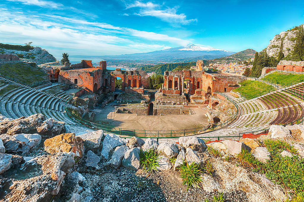 Ruins of ancient Greek theater in Taormina and Etna volcano in Sicily, Italy